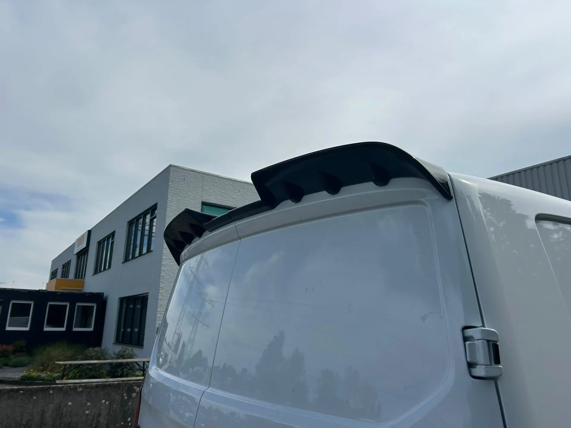 Glanszwarte achterspoiler gemonteerd op Ford Transit Custom en VW Transporter T7